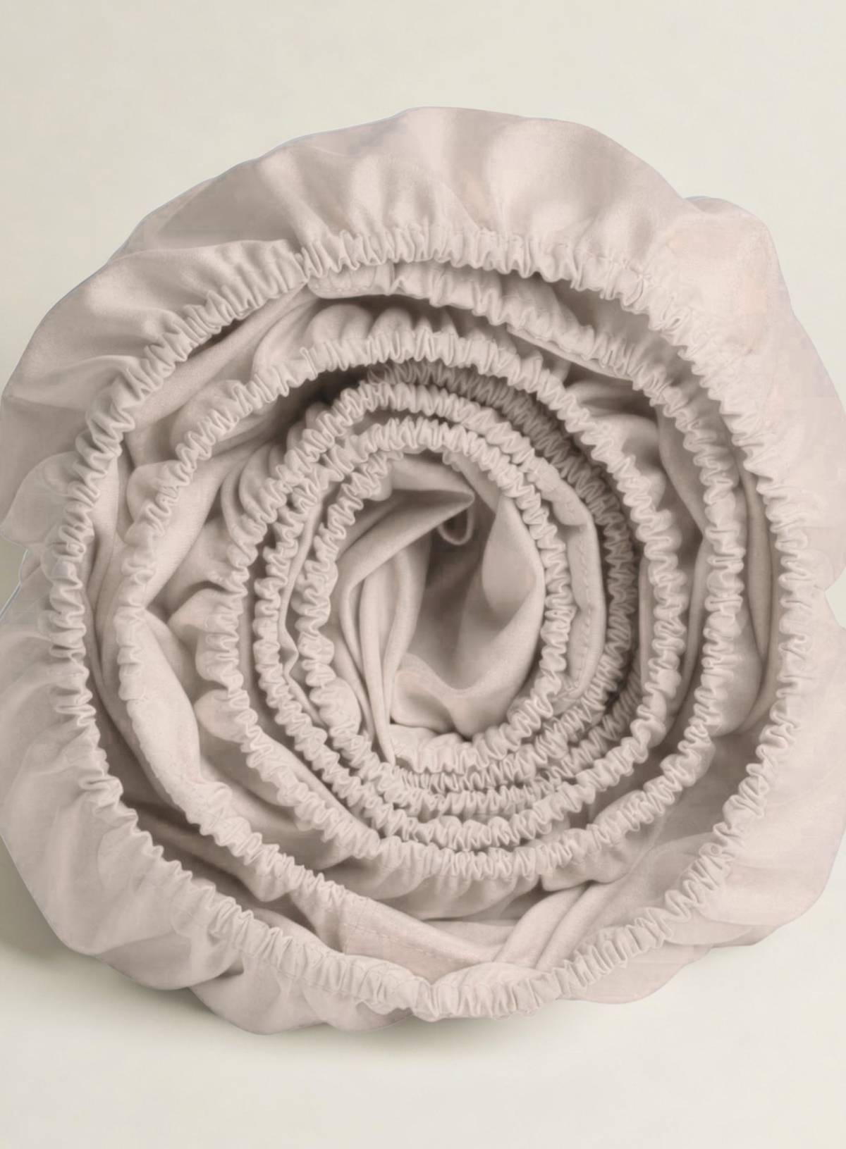 Rolled-up light pink DUVET COVERon a light gray background