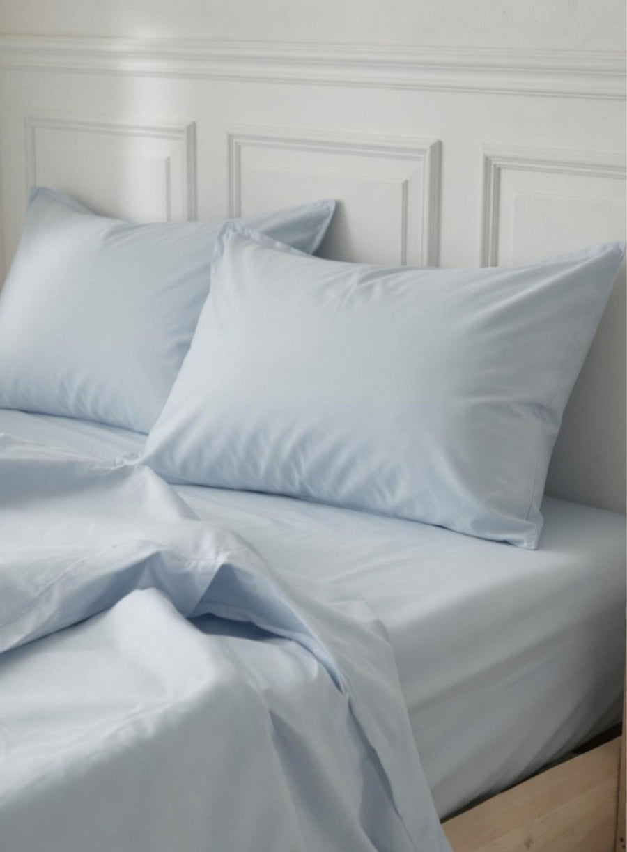 photo of hydrangea pale blue organic pillowcases in a white bedroom