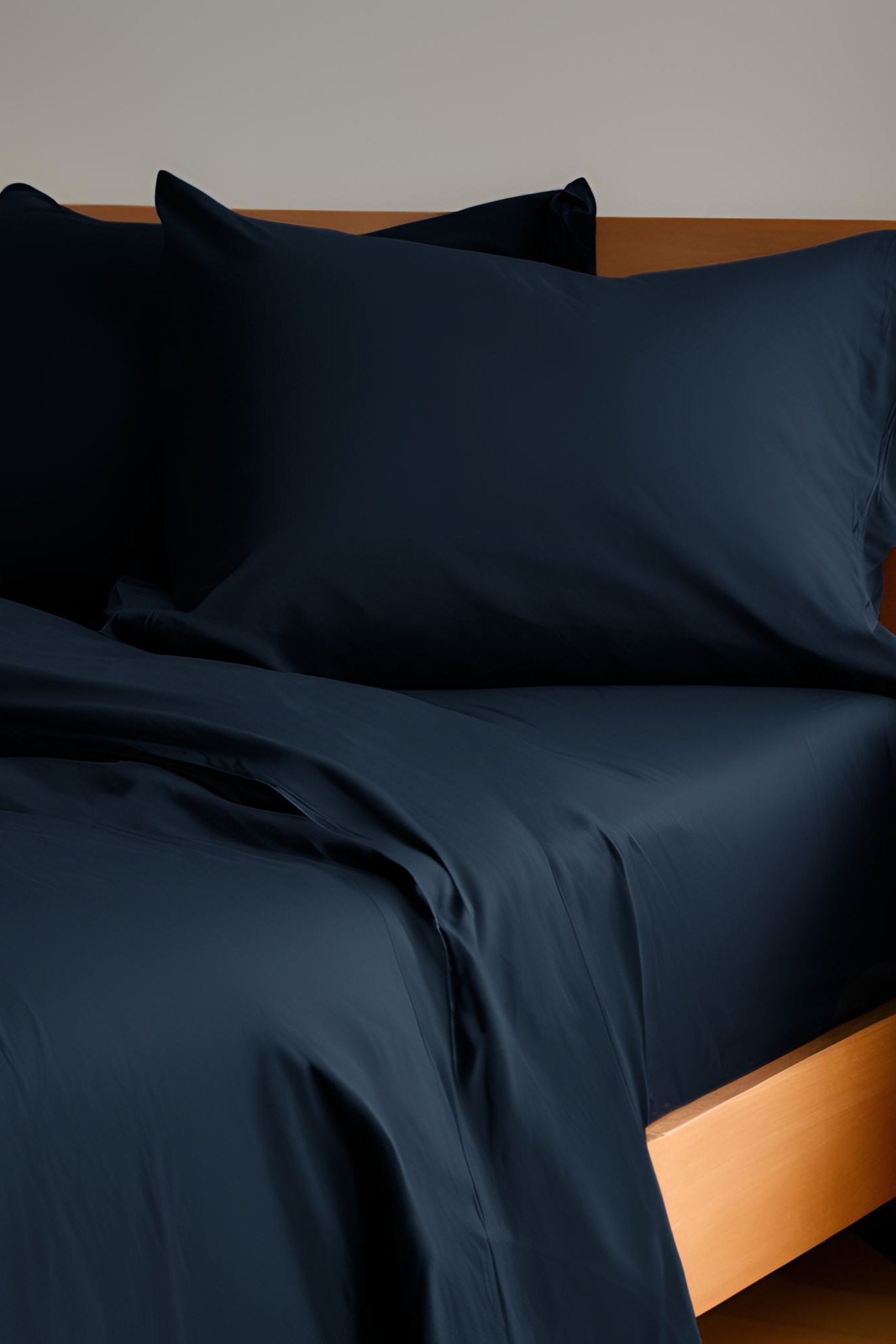 House of March Navy 2026 organic cotton hemmed pillowcase pair with sheets on a bed