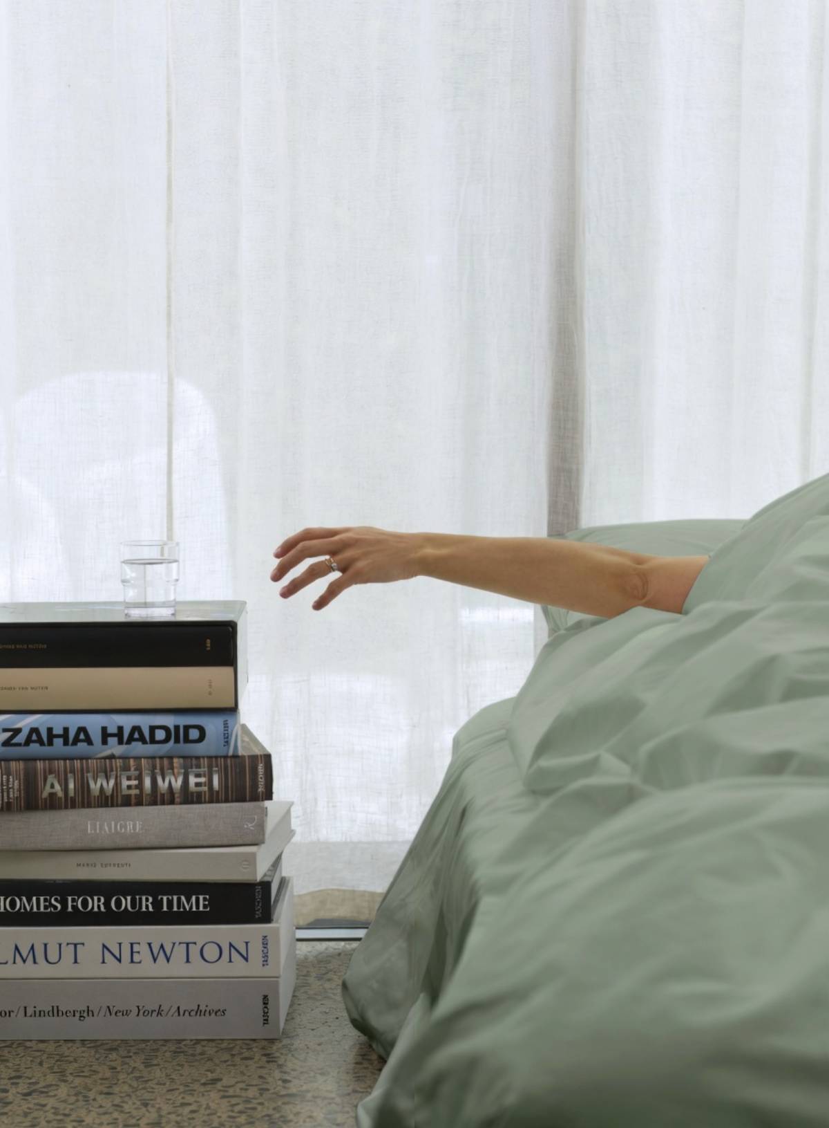 sage duvet cover from house of march with persons arm resachign for glass