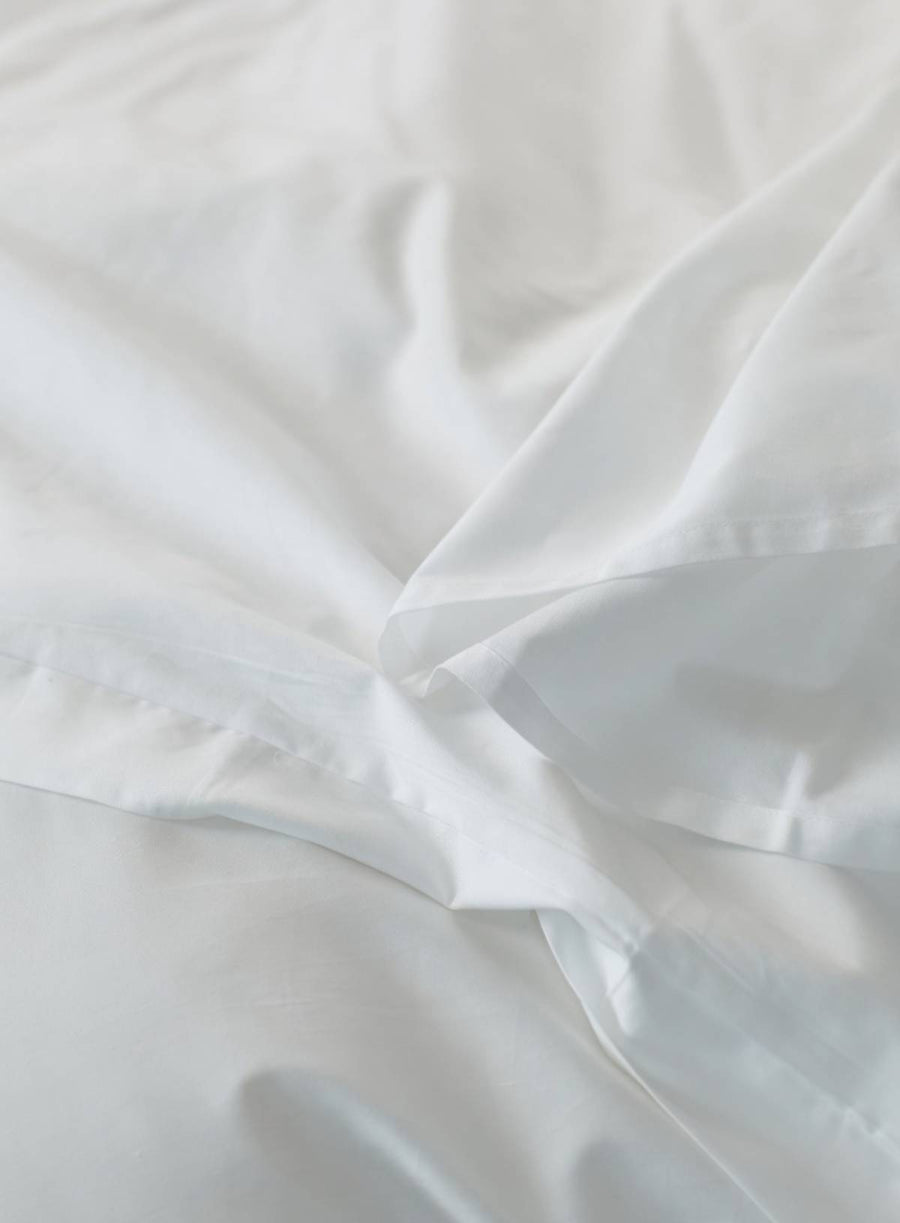 Close-up of white sateen sheet with folds